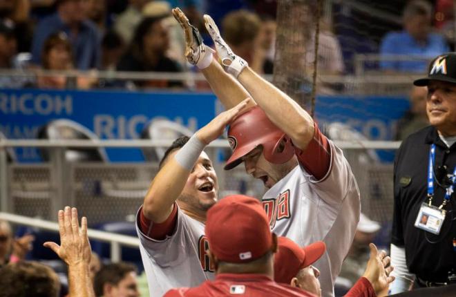 Arizona Diamondbacks'  David Peralta, left, celebrates with A.J. Pollock during the eighth inning of a baseball game against the Miami Marlins in Miami, Tuesday, May 19, 2015, after Pollock hit a go-ahead two-run home run. The Diamondbacks won 4-2. (AP Photo/J Pat Carter)