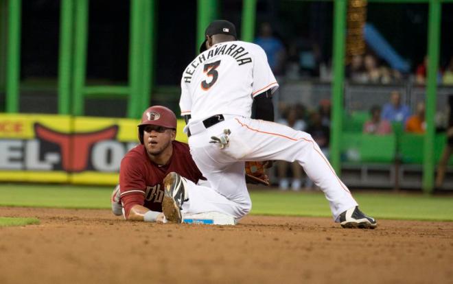 Arizona Diamondbacks  David Peralta (6) jumps back safe to second base on a throw to Miami Marlins shortstop Adeiny Hechavarria (3) during the third inning of a baseball game in Miami, Wednesday, May 20, 2015.  (AP Photo/J Pat Carter)