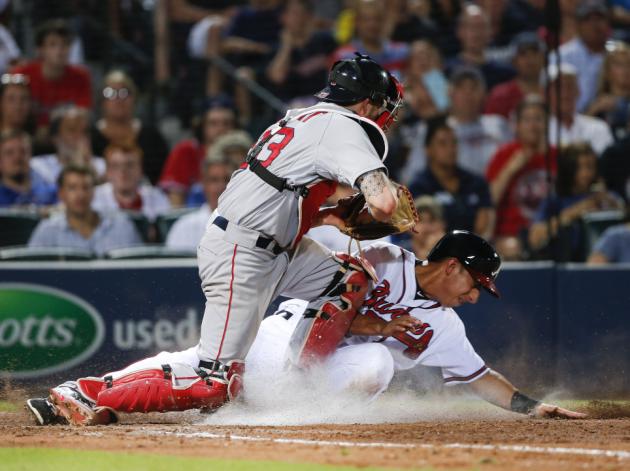 El mexicano Daniel Castro, de los Bravos de Atlanta, es puesto fuera en el plato por el receptor Blake Swihart (23), de los Medias Rojas de Boston, en una roleta de Kelly Johnson en el partido del miércoles 17 de junio de 2015, en Atlanta. (Foto AP/John Bazemore)