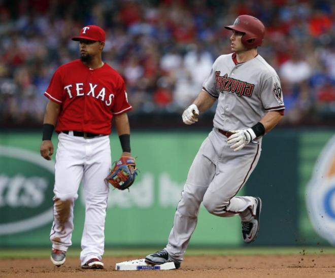 Texas Rangers second baseman Rougned Odor and Arizona Diamondbacks' Paul Goldschmidt look to the outfield as Goldschmidt advances on a single by Yasmany Tomas during the first inning of an interleague baseball game Tuesday, July 7, 2015, in Arlington, Texas. (AP Photo/Tony Gutierrez)