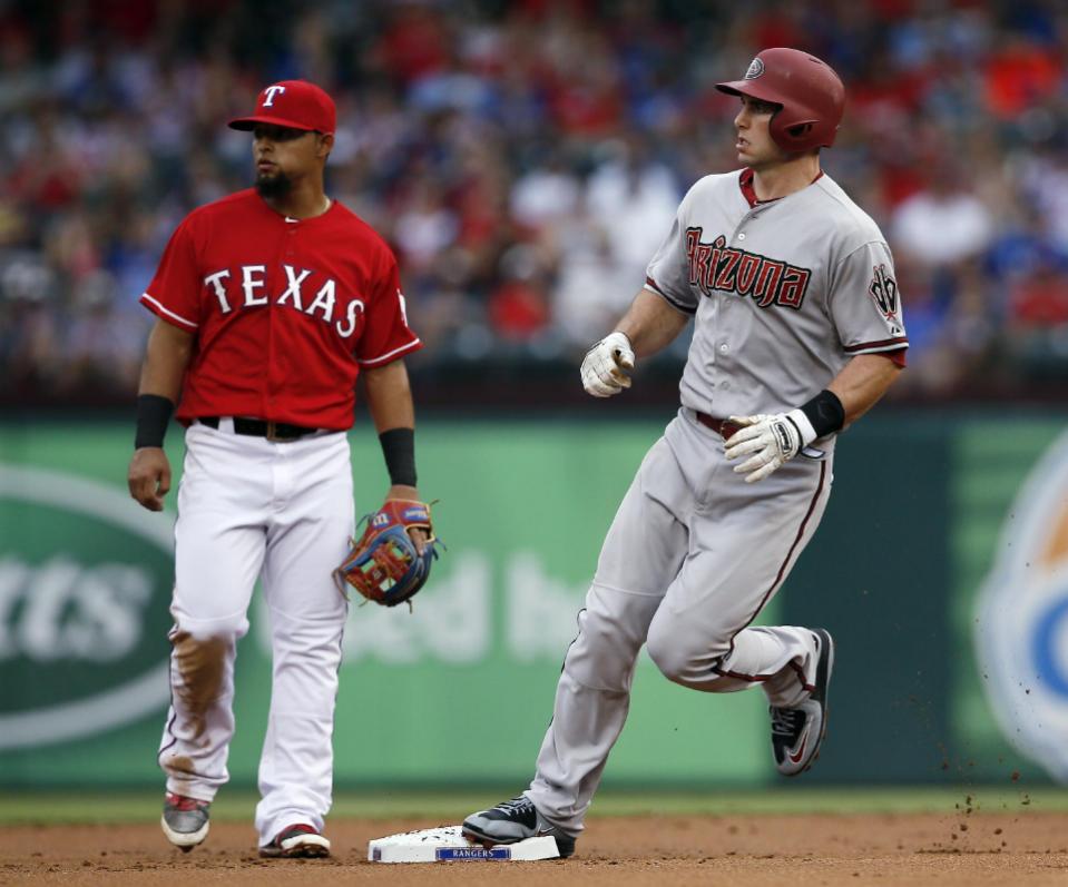Texas Rangers second baseman Rougned Odor and Arizona Diamondbacks' Paul Goldschmidt look to the outfield as Goldschmidt advances on a single by Yasmany Tomas during the first inning of an interleague baseball game Tuesday, July 7, 2015, in Arlington, Texas. (AP Photo/Tony Gutierrez)