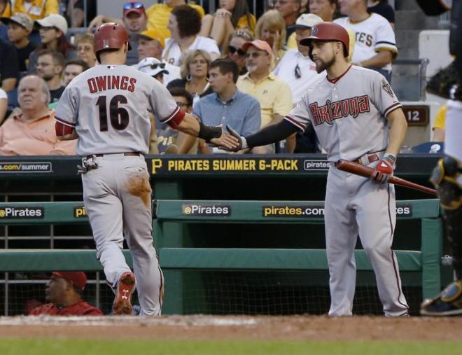 Arizona Diamondbacks' Chris Owings, left, is greeted by on-deck batter Ender Inciarte, right, after scoring on a single by Jeremy Hellickson in the second inning of a baseball game, Monday, Aug. 17, 2015, in Pittsburgh. (AP Photo/Keith Srakocic)