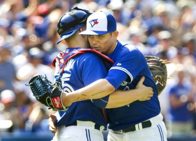 Toronto Blue Jays catcher Martin Russell congratulates pitcher Roberto Osuna on the save after the Blue Jays defeated the New York Yankees 3-1 in a baseball game in Toronto on Sunday, Aug.16, 2015. (Fred Thornhill /The Canadian Press via AP) MANDATORY CREDIT