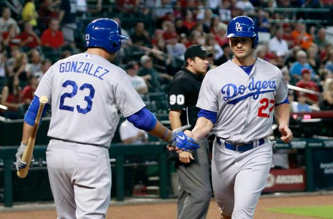 Los Angeles Dodgers' Justin Ruggiano, right, is congratulated by Adrian Gonzalez after scoring against the Arizona Diamondbacks on an RBI single by teammate Justin Turner during the first inning of a baseball game, Sunday, Sept. 13, 2015, in Phoenix. (AP Photo/Ralph Freso)
