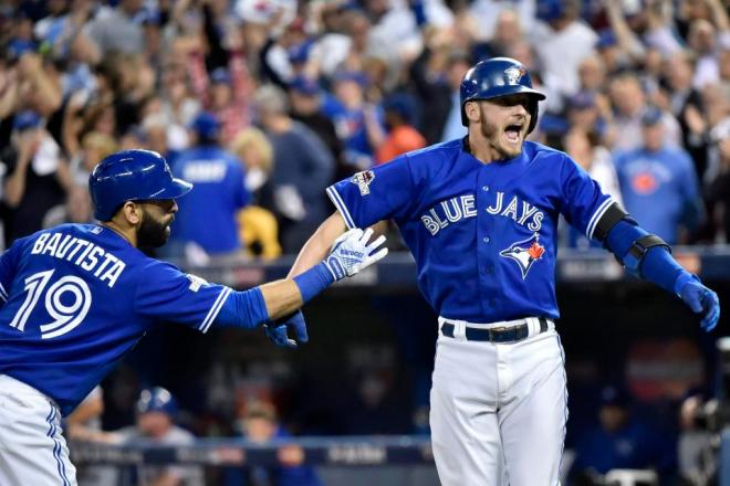 Toronto Blue Jays' Josh Donaldson celebrates with teammate Jose Bautista after hitting a two-run home run during the third inning in Game 3 of baseball's American League Championship Series against the Kansas City Royals on Monday, Oct. 19, 2015, in Toronto. (Nathan Denette/The Canadian Press via AP) MANDATORY CREDIT
