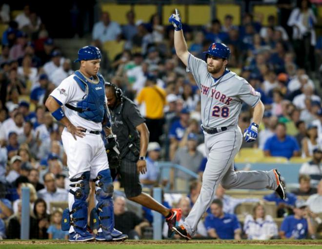 New York Mets' Daniel Murphy celebrates a solo home run as Los Angeles Dodgers catcher A.J. Ellis looks down during the fourth inning in Game 1 of baseball's National League Division Series, Friday, Oct. 9, 2015 in Los Angeles. (AP Photo/Gregory Bull)