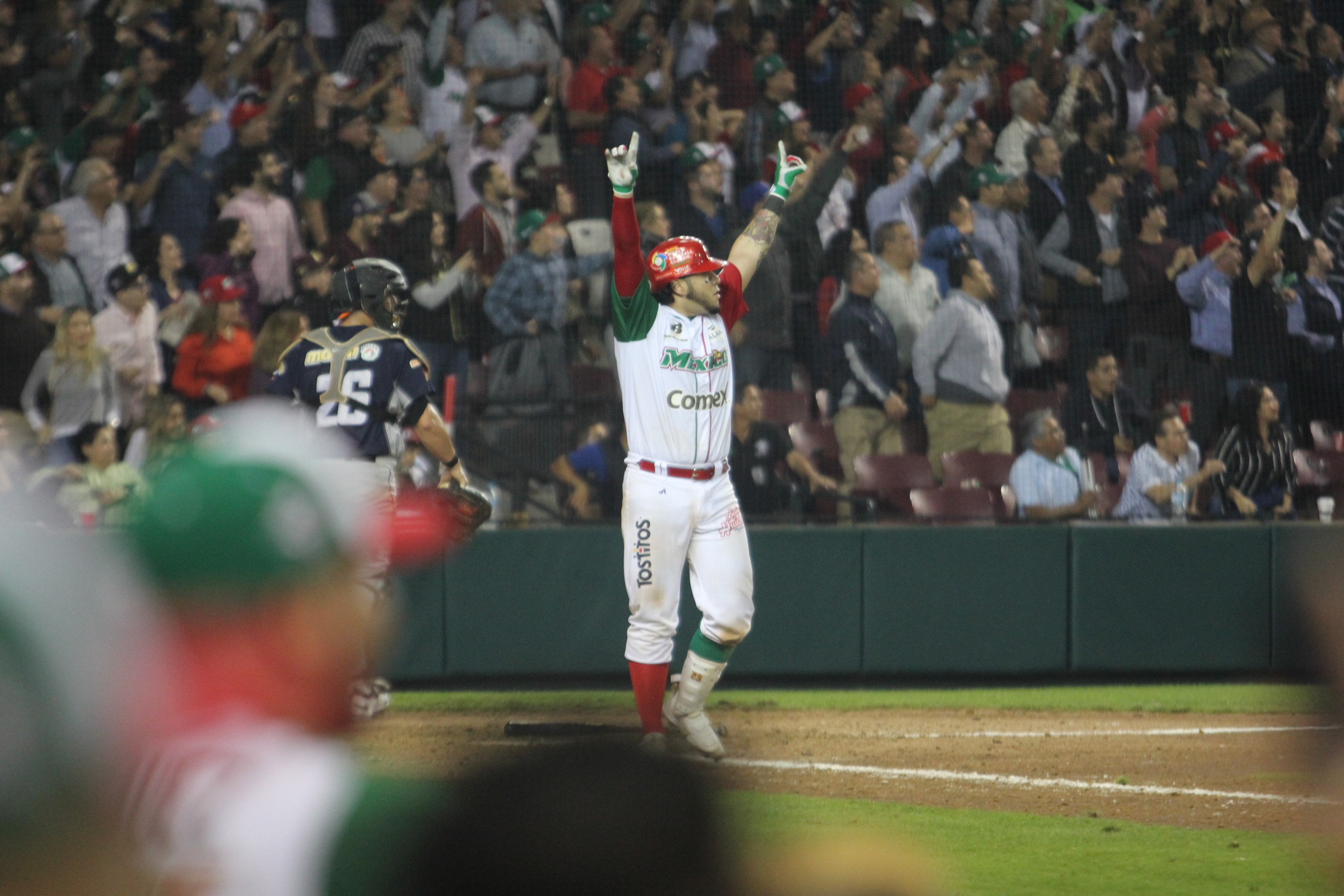 Sebastian Valle levanta los brazos después de conectar el batazo del triunfo.JPG