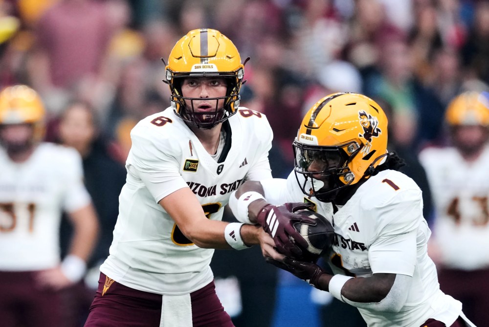 Cutter Boley, de Arizona State, entrega la pelota al corredor de bola, Kyson Brown, en el juego de este sábado en Londres.
